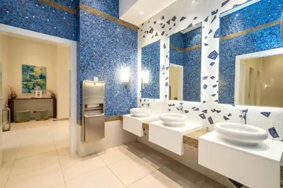 a bathroom with two sinks and blue tiles at High-Floor Elegance | 1-Bedroom with Marina Views in Dubai