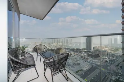 two chairs on a balcony with a view of a city at High-Floor Elegance | 1-Bedroom with Marina Views in Dubai