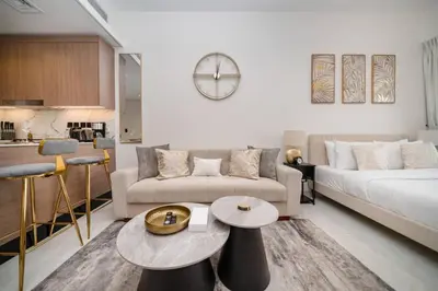 a living room with a couch and a table at Stylish Studio in JVC Bright, Cozy and Convenient in Dubai