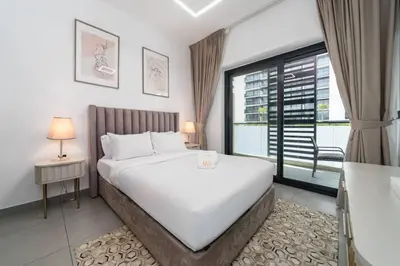 a bedroom with a large bed and a large window at Modern JVC 1-Bed Pool, Gym and Family Amenities in Dubai