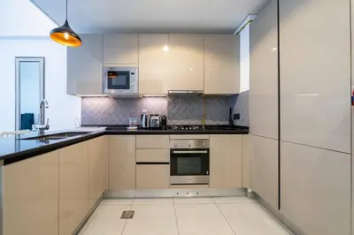 a kitchen with white cabinets and stainless steel appliances at Modern JVC 1-Bed Pool, Gym and Family Amenities in Dubai