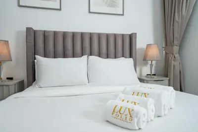 a bedroom with a bed with towels on it at Modern JVC 1-Bed Pool, Gym and Family Amenities in Dubai