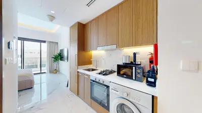 a kitchen with a stove and a washer and dryer at Azizi Riviera 61 - Serene Studio in Meydan in Dubai