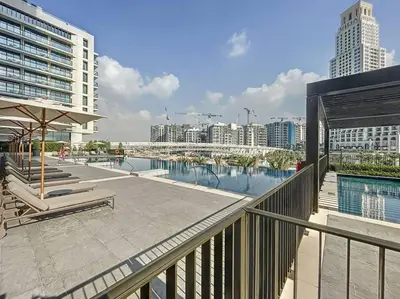 a balcony with a swimming pool in a city at Vacationer Chic 1 Bedroom Creek Harbour in Dubai
