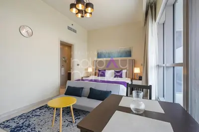 a bedroom with a bed and a table and a couch at Elegant Studio apartment in Avanti Tower Business Bay in Dubai