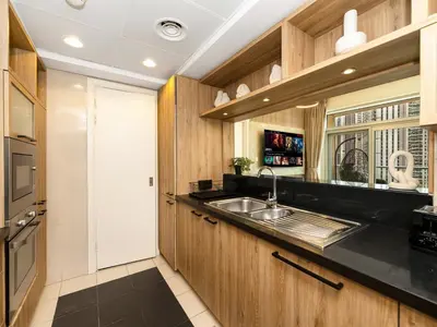 a kitchen with wooden cabinets and a sink at Luxury Stay in Downtown-Steps to Burj & Dubai Mall in Dubai