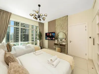a bedroom with two beds and a large window at Luxury Stay in Downtown-Steps to Burj & Dubai Mall in Dubai
