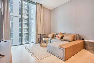 a living room with a couch and a large window at STAY BY LATINEM Luxury 1BR Holiday Home CVR B 602 near Downtown in Dubai