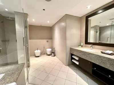 a bathroom with two sinks and a shower and a toilet at Specious 1 Br In Royal Amwaj Residences South in Dubai
