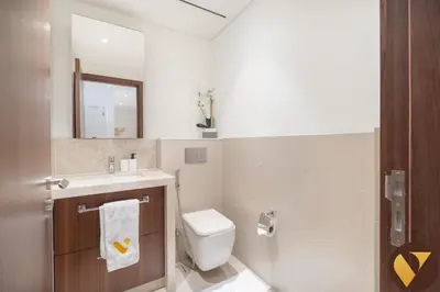 a bathroom with a toilet and a sink and a mirror at Vogue Downtown Boulevard Point near Burj Khalifa and Dubai Mall, One Bedroom Apartment with Burj Khalifa view from the Balcony and Access to all Amenities in Dubai