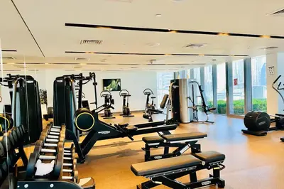 a gym with several treadmills and machines in a room at Vogue Downtown Boulevard Point near Burj Khalifa and Dubai Mall, One Bedroom Apartment with Burj Khalifa view from the Balcony and Access to all Amenities in Dubai