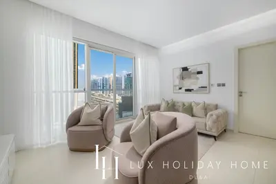 a living room with two chairs and a couch at LUX The West Avenue Dubai Marina Suite in Dubai