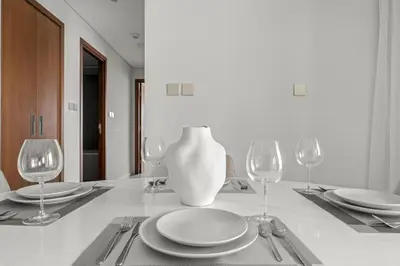 a dining room table with plates and wine glasses at FIRST CLASS 2BR Creek Beach Comfort & Style in Dubai