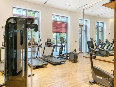 a gym with several treadmills and elliptical machines at FIRST CLASS 2BR Creek Beach Comfort & Style in Dubai