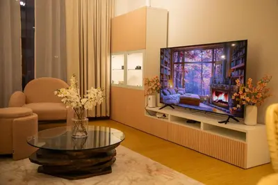 a living room with a flat screen tv and a table at Stylish Beachfront Creek Escape in Dubai