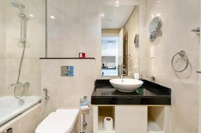 a bathroom with a sink and a toilet and a tub at White Sage Damac Hills Cozy Artesia Studio in Dubai