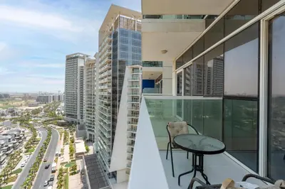 a balcony with a table and views of a city at White Sage Damac Hills Cozy Artesia Studio in Dubai