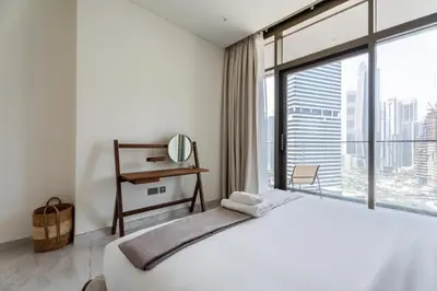 a bedroom with a large bed and a large window at GuestReady - 1BR l Canal View | Near Dubai Mall in Dubai