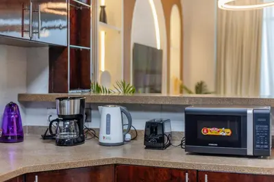 a kitchen counter with a microwave and appliances on it at Luxury 3 BHK High Floor Pool, Gym Sauna Opal 2705 in Dubai