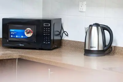 a microwave sitting on a counter next to a kettle at Luxury 3 BHK High Floor Pool, Gym Sauna Opal 2705 in Dubai