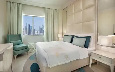 a bedroom with a bed and a desk and a chair at Mayfair Luxury Apartment in 5-Star DAMAC Maison Mall Street Building, Downtown Dubai in Dubai