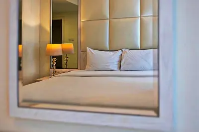 a bedroom with a large bed with a mirror at Mayfair Luxury Apartment in 5-Star DAMAC Maison Mall Street Building, Downtown Dubai in Dubai