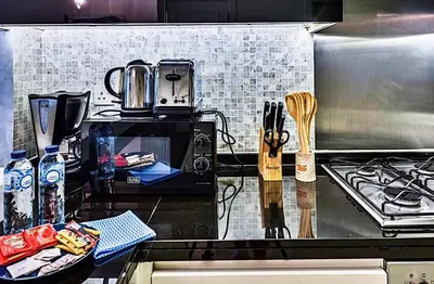 a kitchen with a stove and a counter top with utensils at Mayfair Luxury Apartment in 5-Star DAMAC Maison Mall Street Building, Downtown Dubai in Dubai