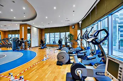 a gym with exercise bikes and a tv in it at Mayfair Luxury Apartment in 5-Star DAMAC Maison Mall Street Building, Downtown Dubai in Dubai