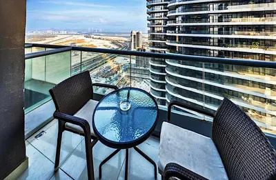 a table and chairs on a balcony with a building at Mayfair Luxury Apartment in 5-Star DAMAC Maison Mall Street Building, Downtown Dubai in Dubai