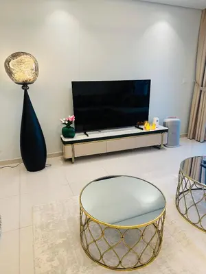 a living room with a table and a tv at Plush & Modern 2BR Luxury stay with picturesque Rooftop 64th floor in Dubai