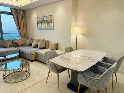 a living room with a table and a couch at Plush & Modern 2BR Luxury stay with picturesque Rooftop 64th floor in Dubai