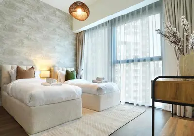 a bedroom with two beds and a large window at Chic 2BR in Downtown, 5 Min Walk to Burj Khalifa in Dubai