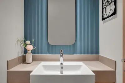 a bathroom with a sink and a blue curtain at Burj View Direct to Dubai Mall 2BR in Dubai