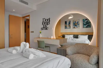a hotel room with two beds and a chair at Burj View Direct to Dubai Mall 2BR in Dubai