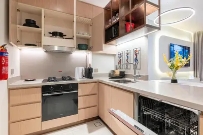a kitchen with wooden cabinets and an oven at Burj View Direct to Dubai Mall 2BR in Dubai