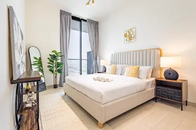 a bedroom with a large bed and a large window at Luxury 1BR in Binghatti Onyx JVC with Pool, Gym & Balcony in Dubai