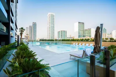 a swimming pool with a city skyline in the background at Luxury 1BR in Binghatti Onyx JVC with Pool, Gym & Balcony in Dubai