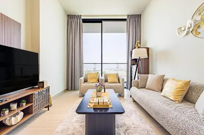 a living room with a couch and a tv at Luxury 1BR in Binghatti Onyx JVC with Pool, Gym & Balcony in Dubai