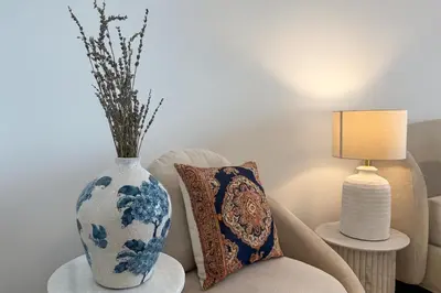 a blue and white vase sitting on a table next to a chair at Stylish Studio 10 Mins from Dubai Mall Meydan Area in Dubai