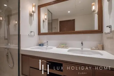 a bathroom with two sinks and a mirror at LUX The Palace Residence Suite 2 in Dubai