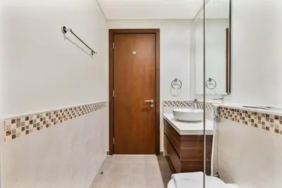a bathroom with a wooden door and a sink at Luxury 2 Bed with Iconic Burj View, Near Dubai Mall in Dubai