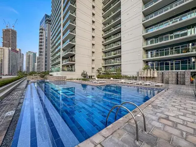 a large swimming pool in front of a tall building at Luxury 2 Bed with Iconic Burj View, Near Dubai Mall in Dubai