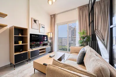 a living room with a couch and a tv at Modern 1BR at Collective Dubai Hills Mall Nearby in Dubai