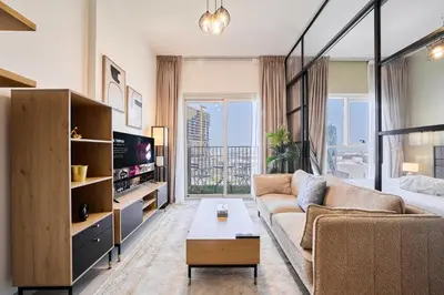 a living room with a couch and a tv at Modern 1BR at Collective Dubai Hills Mall Nearby in Dubai