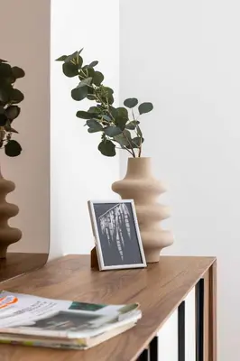 a table with a picture and a vase on it at Frank Porter - Bayshore at Creek Beach Building 4 in Dubai