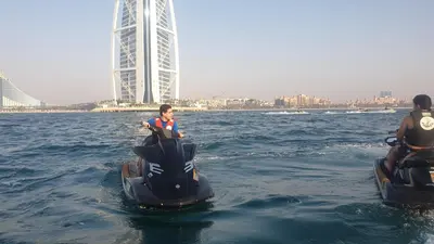 two people riding on an jet ski in the water at A one sports jetski rental in Dubai