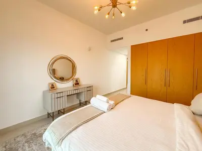 a bedroom with a large bed and a mirror at Zinnia Luxury 2BHK Bellevue Burj Khalifa View in Dubai