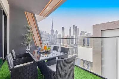 a balcony with a table and chairs and a view of the city at Water Dream with Burj Views Sleeps 4 in Dubai
