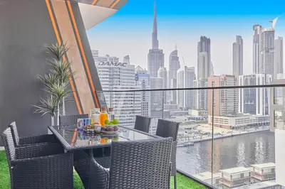 a balcony with a table and chairs and a view of a city at Water Dream with Burj Views Sleeps 4 in Dubai