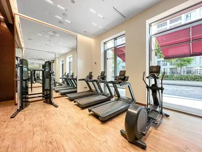 a gym with a row of treadmills and elliptical machines at FIRST CLAS 1BR Creek Beach , Lagoon Access in Dubai